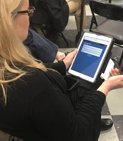 A woman takes a survey on a tablet.
