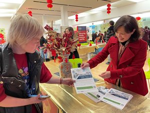 A member of the Chinese American Cultural Association distributes flyers about an NJTPA-funded study during a Lunar New Year Celebration at Bridgewater Mall.