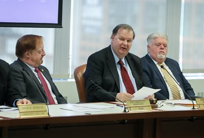 NJTPA Chair John P. Kelly, center, speaks at the January 8 Board meeting as Commissioners John Bartlett, left, and Charles Kenny, right, look on.