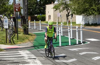 A man rides a bicycle in a temporary bike lane.