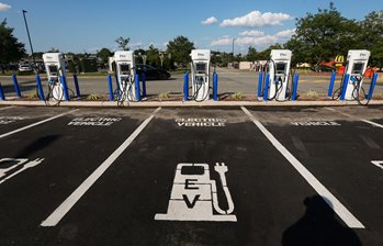 5 electric vehicle chargers are shown in a parking lot.